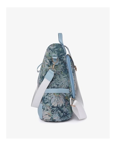 Side view of floral jacquard nylon backpack with blue faux leather trim and white straps