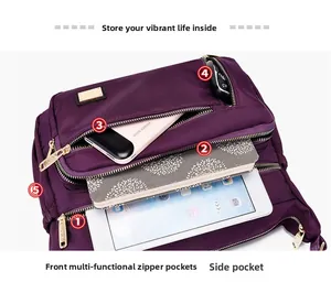 Detail of purple nylon shoulder bag showing multiple zipper pockets and internal storage space