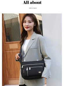 Close-up of black nylon shoulder bag with silver zippers and stylish woven strap
