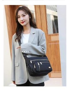 Detail of black waterproof oxford bag with multi-zipper pockets and wide shoulder strap