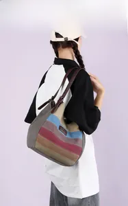 Détail du sac cabas en toile rayée multicolore avec bandoulière réglable en cuir marron