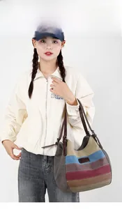 Détail d'un grand sac en toile à rayures multicolores et anses en cuir marron