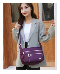 Detail view of purple multi-pocket oxford crossbody bag with adjustable wide strap
