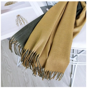 Detail of two-tone ginger and dark green scarf with soft fringe and twill texture