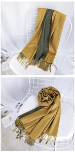 Close-up of ginger yellow and dark green thick scarf with long tassel details