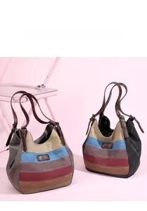 Détail du sac cabas en toile à rayures colorées avec poignées en cuir et logo