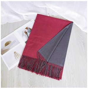 Detailed flat lay of double-sided burgundy and grey scarf with fine tassel edges