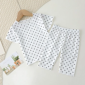 Close-up of baby girl polka dot pajama set featuring breathable ribbed cotton and wavy edges