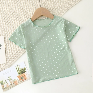 Detail of light green polka dot baby shirt featuring ruffled lettuce edges and ribbed fabric