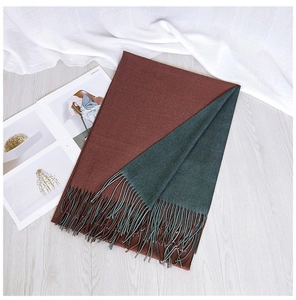 Detailed view of the double-sided red and green scarf with fringes on a cozy background