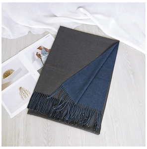 Detail view of two-tone navy and grey scarf featuring elegant fringe and soft knit texture