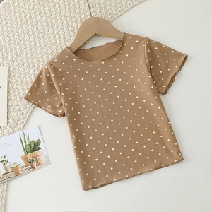 Detail of brown polka dot baby pajama set featuring ribbed fabric and ruffled lettuce edges