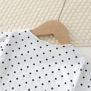 Detail of baby girls' polka dot pajama top with ruffled collar and ribbed texture