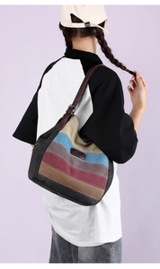Détail de la bandoulière en cuir réglable et de la toile à rayures du sac vintage