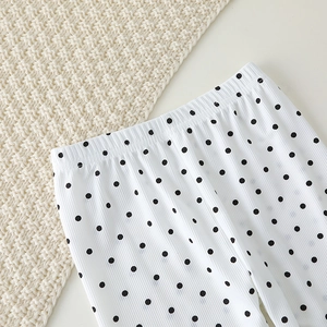 Detail of white toddler pants with black polka dots and vertical ribbed knit texture