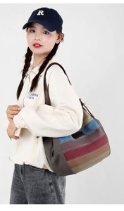 Détail d'un sac cabas en toile à rayures multicolores avec lanières en cuir sur modèle