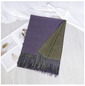 Detail of two-tone purple and green scarf with fringe on light wood floor
