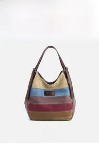 Détail du cabas en toile rayée multicolore avec poignées en cuir marron et logo gravé