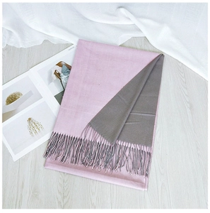 Close-up of dual-color pink and grey winter scarf with soft handmade tassels detail