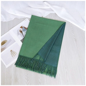Detail of light and dark green double-sided scarf with elegant tassel fringe
