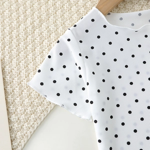 Detail of baby summer pajama top with polka dots and ruffled edges on ribbed fabric
