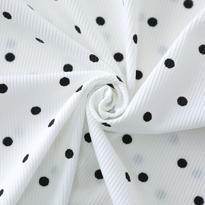 Close-up of ribbed white cotton fabric with black polka dots for children's pajamas