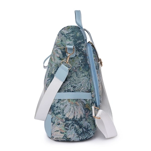 Floral nylon backpack with blue leather trim and wide woven strap on white background
