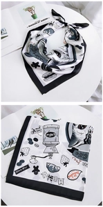 Close-up of cat-themed square scarf featuring coffee and croissant illustration