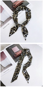 Détail d'un foulard étroit en soie à motif léopard noué en ruban élégant