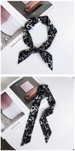 Détail d'un foulard étroit en soie à motif léopard noué comme une cravate élégante