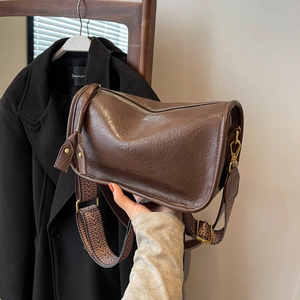 Deep brown litchi pattern saddle bag with stylish wide jacquard wave strap and top zipper
