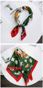 Detail of green silk scarf with cartoon cat and strawberry prints on white background