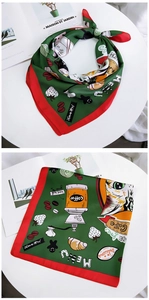 Detail of silk square scarf featuring dark green cat and coffee patterns with red border