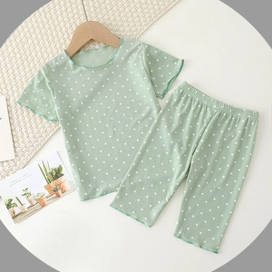 Girl's mint green polka dot pajamas set with ruffled trim and ribbed fabric