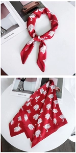 Détail d'un foulard en soie rouge avec motif cygne et vue de la finition nouée élégante