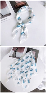 Détail d'un foulard carré en soie blanc avec des vagues bleues et des motifs de cygne
