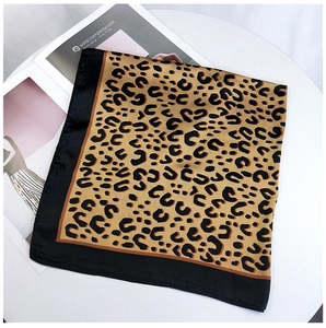 Detailed view of leopard print square scarf on magazine atop white table
