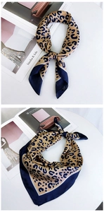 Detail of leopard print silk scarf with navy blue borders tied in elegant knots