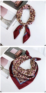 Detail of red and beige leopard print square silk scarf folded on a fashion magazine