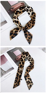 Détail d'un foulard twilly à imprimé léopard noué avec étiquette d'entretien