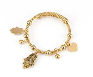 Detail of 18K gold-plated stainless steel wire bracelet with Hamsa Hand and heart pendants
