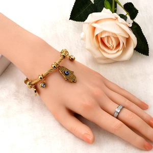 Golden Hamsa hand wire bracelet with evil eye charm and a sparkling paved screw ring