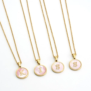 Macro detail of 18K gold stainless steel necklaces with pink shell KISS letters