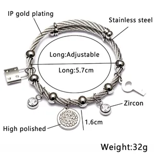 Detailed close-up of adjustable stainless steel cable bracelet with zircon lock and key pendants