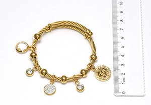 Close-up of gold tree of life charm and rhinestones on cable texture bangle bracelet
