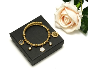 Close-up of 18K gold-plated steel cable bracelet with Tree of Life and crystal charms