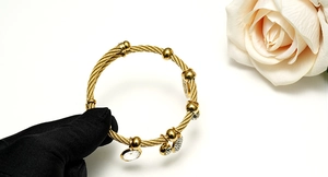 Detail of 18K gold-plated cable tree of life bracelet with crystal-studded charms