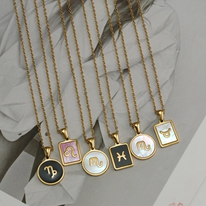 Dettaglio delle collane zodiacali placcate in oro 18K con ciondoli in madreperla e smalto