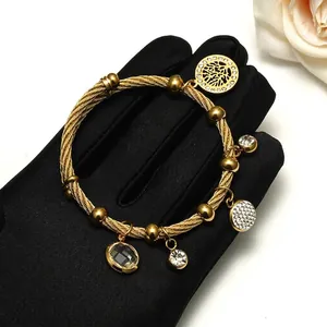 18K gold plated stainless steel tree of life charm bracelet on black velvet background