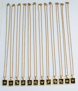 Flat lay verticale di dodici collane con ciondoli zodiacali in acciaio inossidabile 18K
